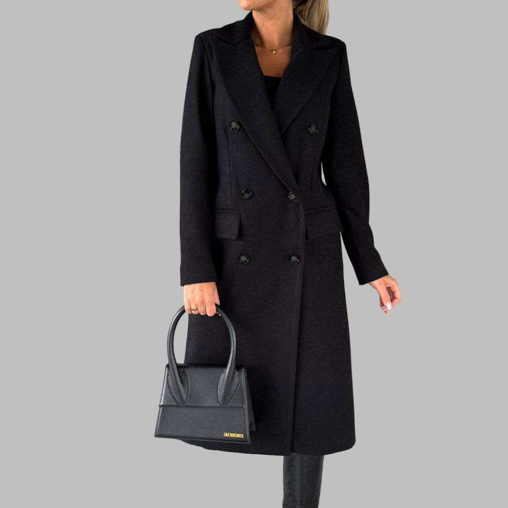 Zwarte winterjas voor dames, dubbele rij knopen, elegante lange mantel, gecombineerd met zwarte handtas en laarzen, modieuze winterkleding.